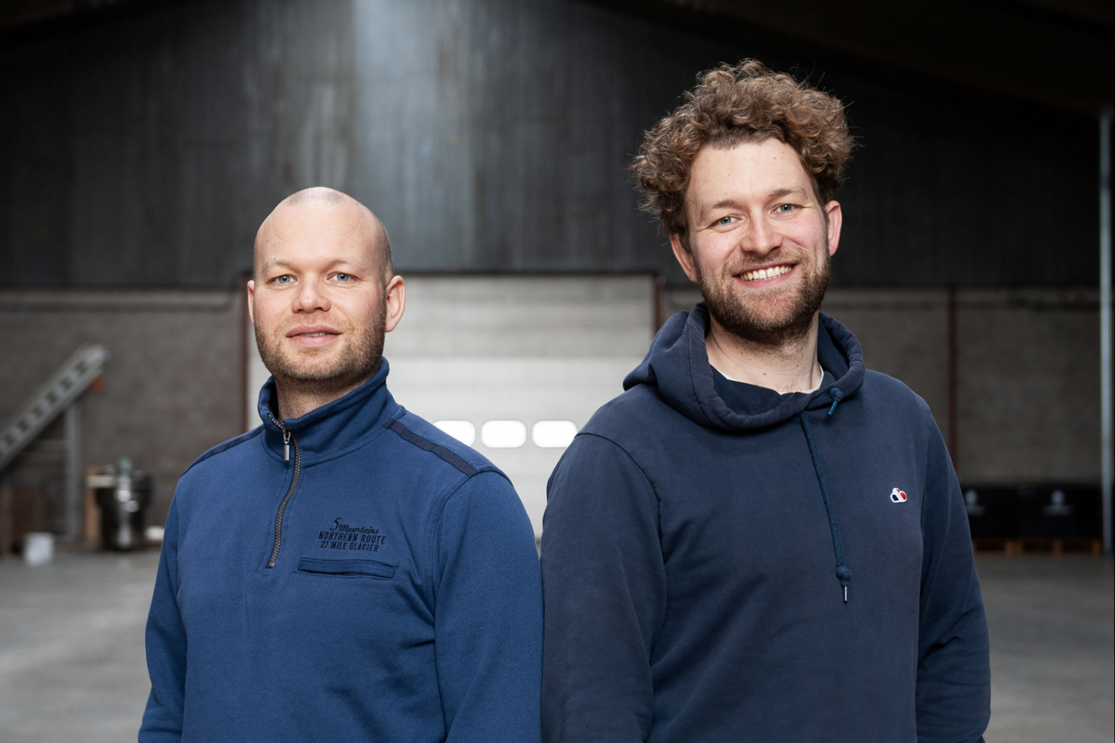 De nieuwe melkboeren Tom en Bart Grobben in de nu lege koeienstal van hun ouders.