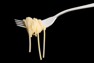 Spaghetti op een vork tegen een zwarte achtergrond