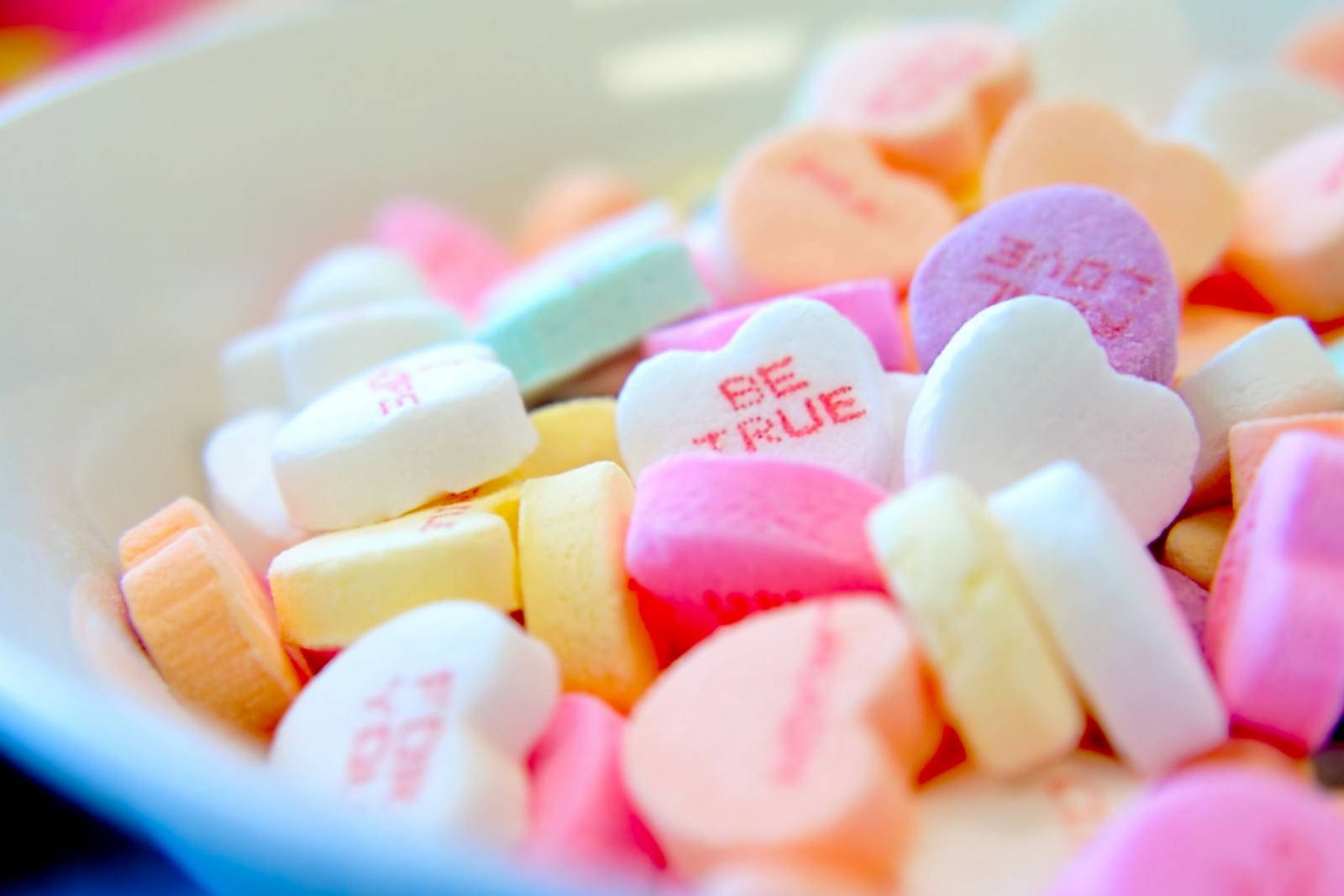 Heel veel gekleurde suikerhartjes met teksten als Be True, For you, Love en Kiss.