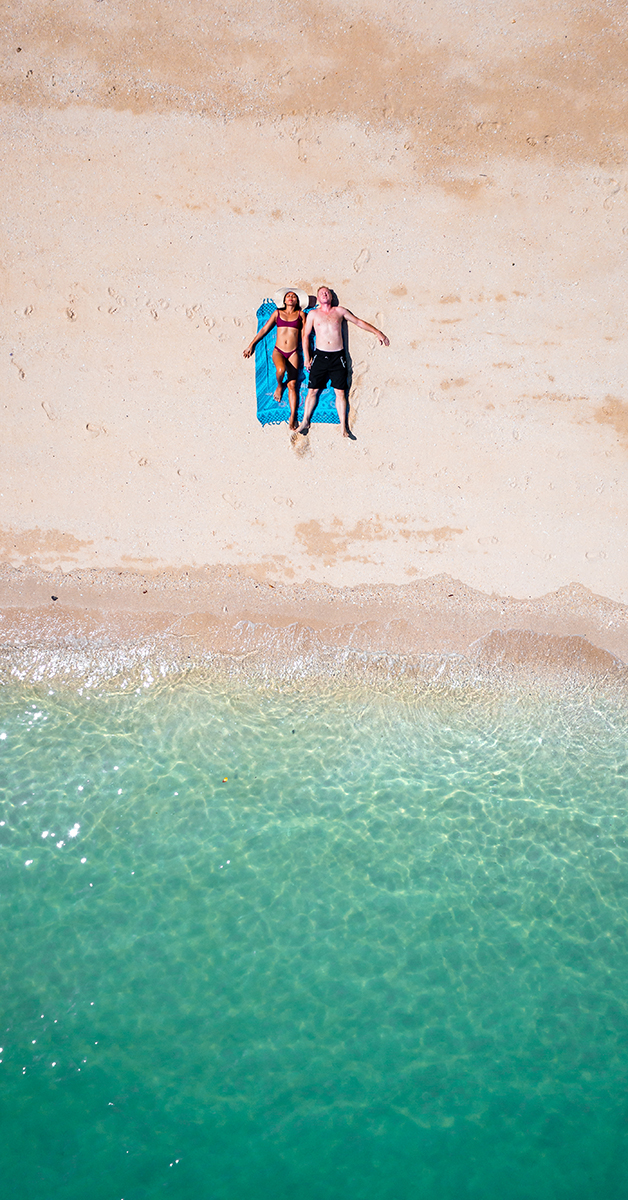 Stel is aan het zonnebaden op het strand