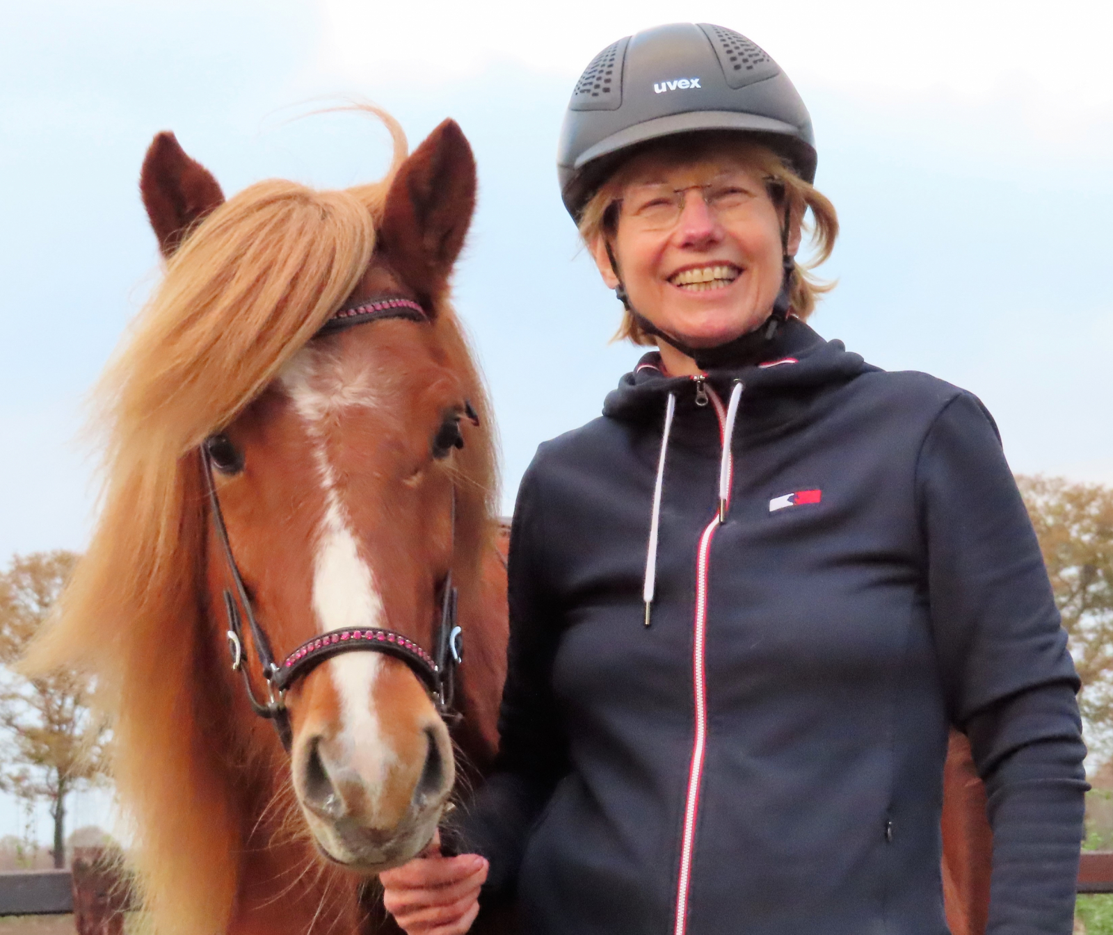 Loethe Olthuis met cap en bruin paard aan rechterhand