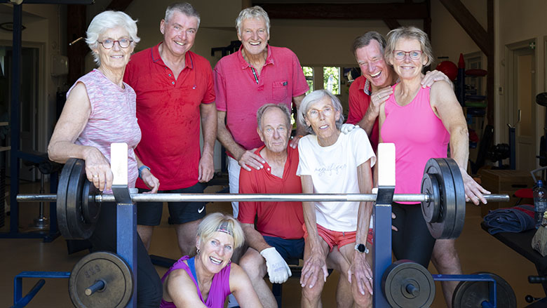 Groepje mensen die samen sporten in de gymzaal